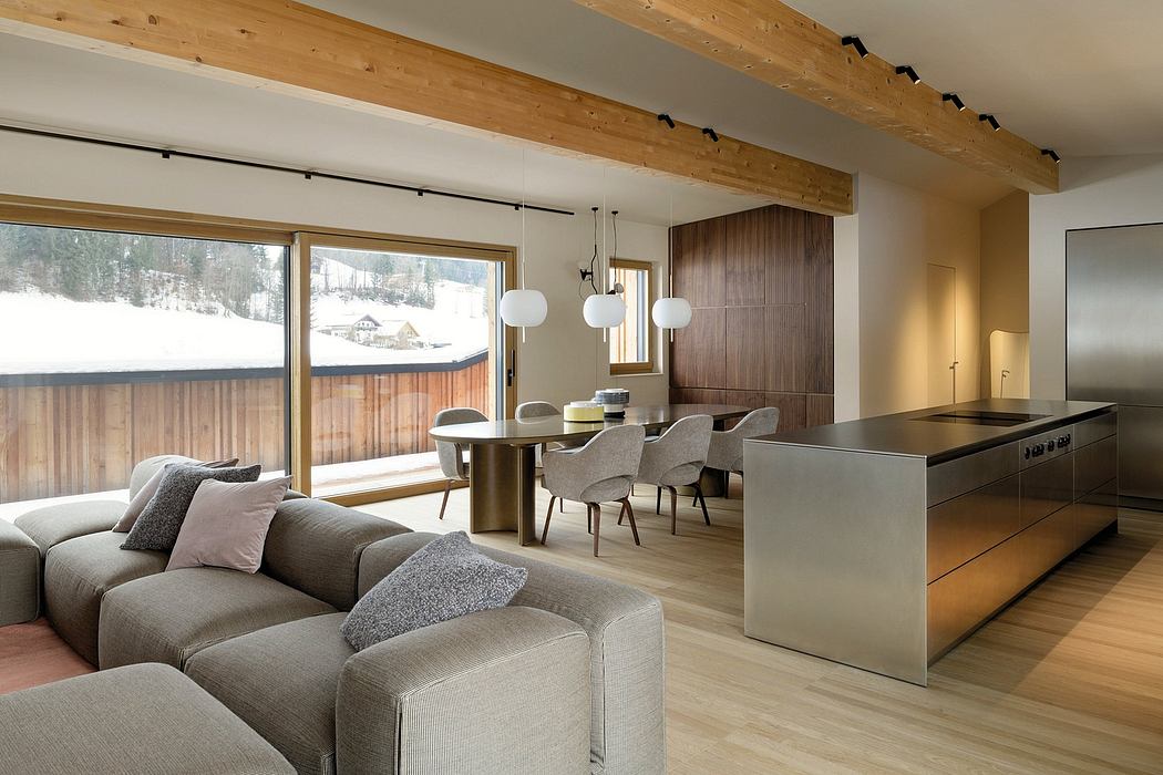 Cozy, modern mountain home with exposed wooden beams, large windows, and sleek kitchen.