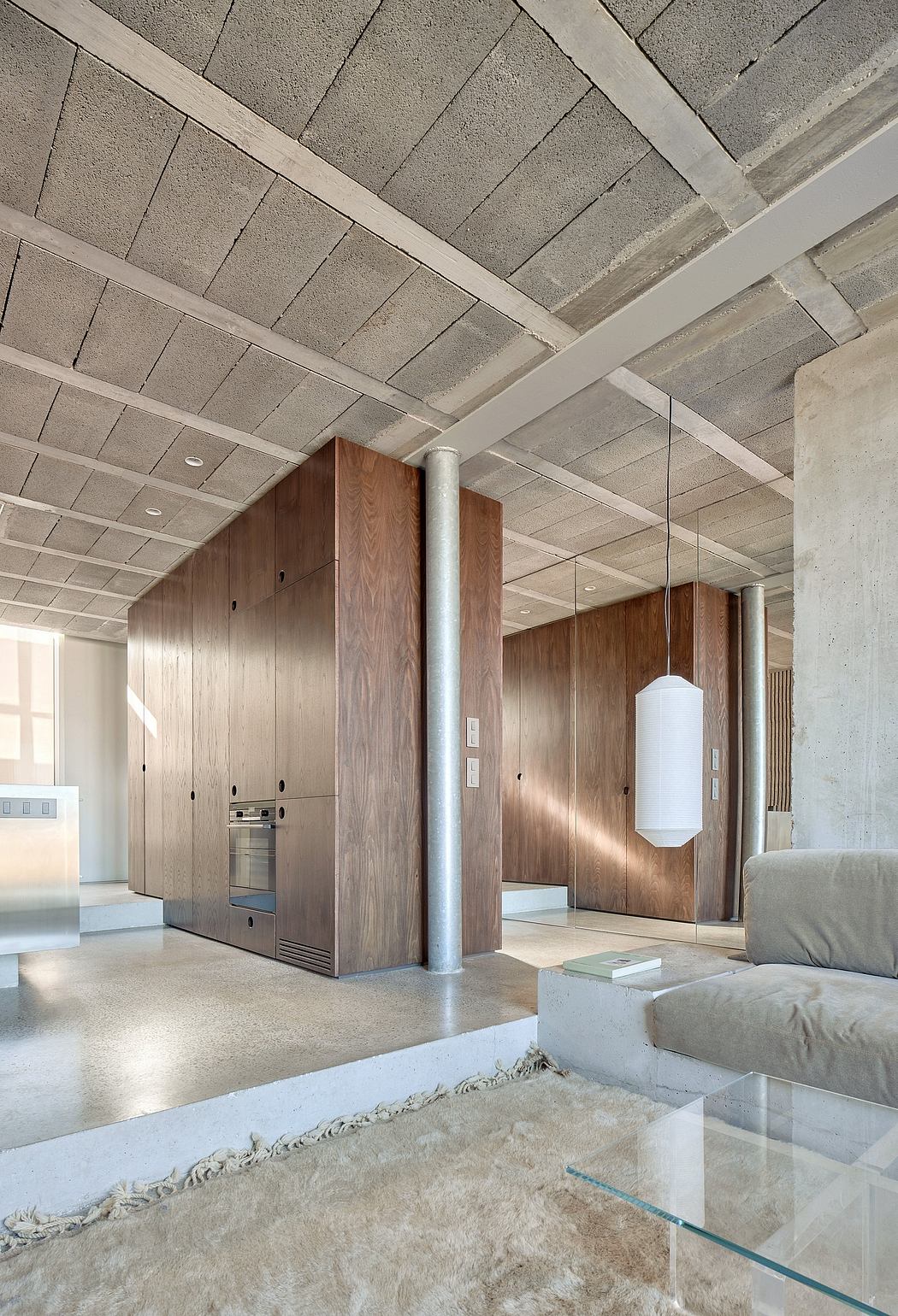 A modern, minimalist interior with exposed concrete ceilings, wood paneling, and built-in appliances.