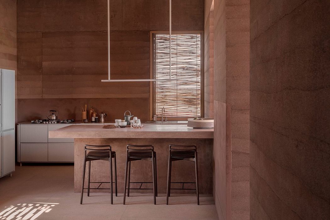 Rustic kitchen with natural stone walls, wood countertop, and minimalist pendant lighting.