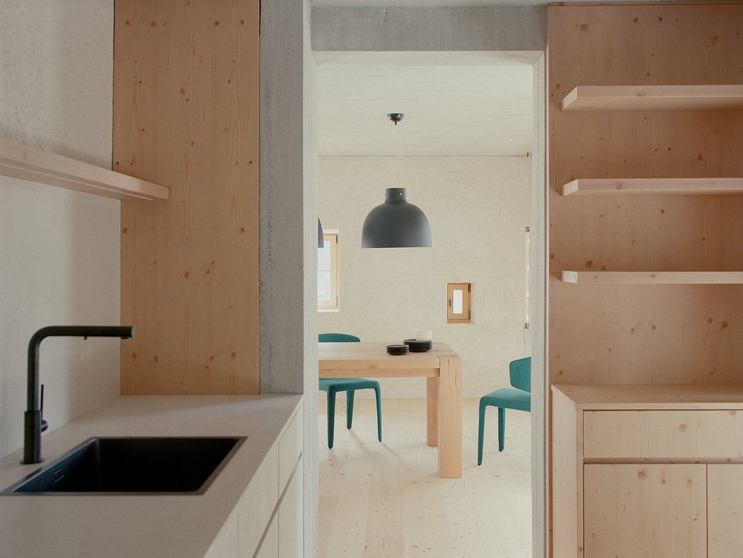 A modern, minimalist kitchen and dining area with natural wood and neutral tones.