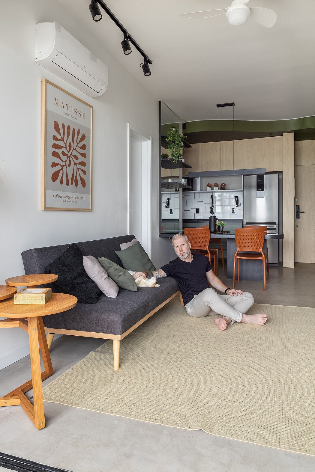 Modern apartment with Matisse artwork, sleek kitchen, comfortable sofa, and clean design.