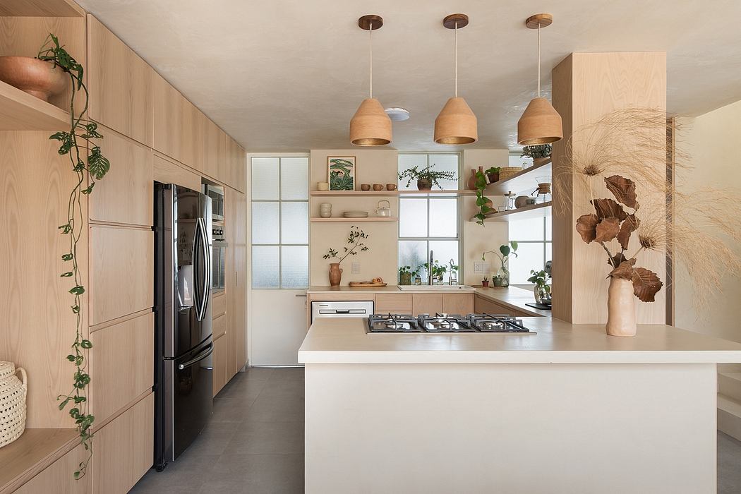A modern, light-filled kitchen featuring wood accents, pendant lighting, and integrated storage.