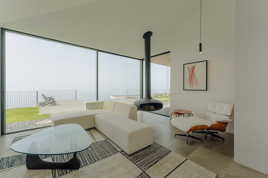 Minimalist living room with modern fireplace, large windows, and sleek furniture.