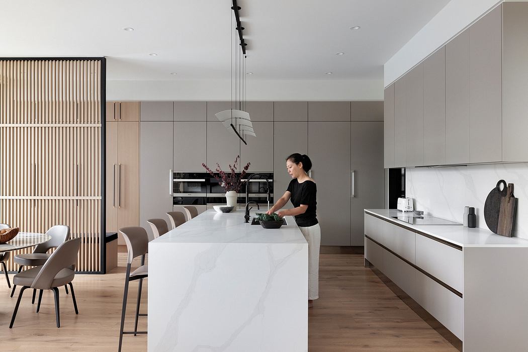 A modern, minimalist kitchen with clean lines, sleek cabinets, and a large central island.