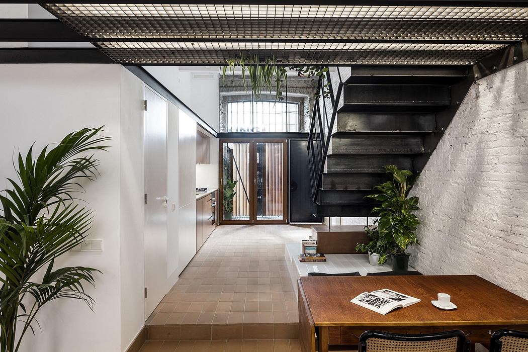 A modern industrial-style interior with exposed beams, brick walls, and lush plants.