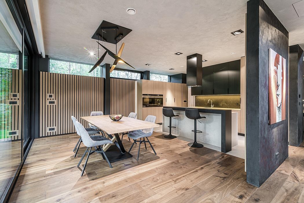 Open, modern kitchen and dining area with sleek black and wood design elements.