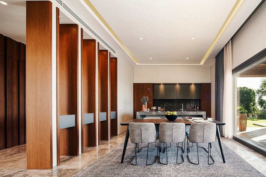 Modern open-concept kitchen and dining area with sleek wood paneling, minimalist furniture, and large windows.