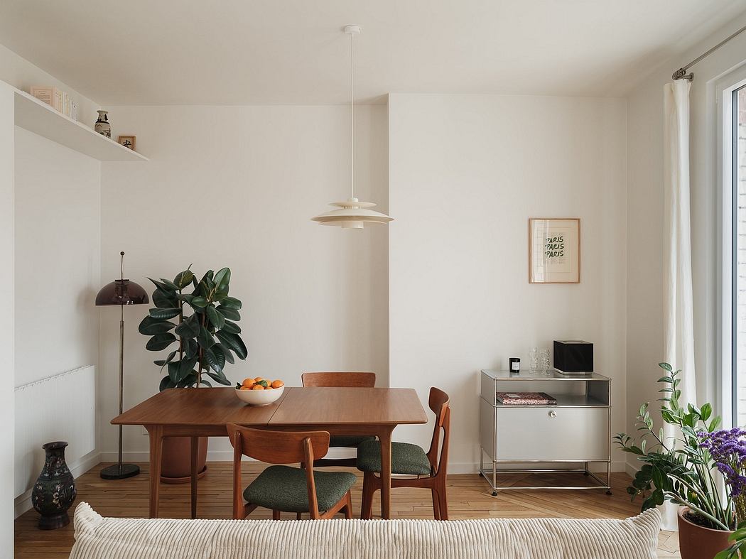 Minimalist dining room with a mid-century modern table, chairs, and decor accents.