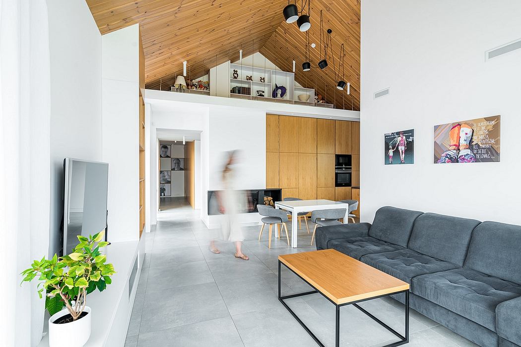 Modern, open-concept living space with wood-paneled vaulted ceiling, minimalist furniture.