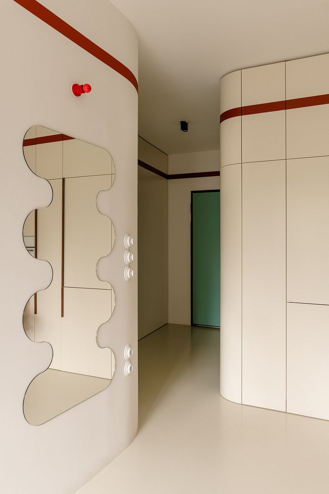 Minimalist hallway with geometric white cabinets, accented by red and green details.