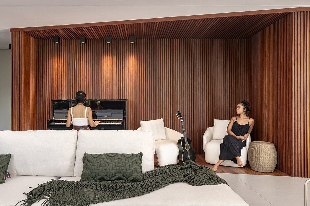 A modern living room featuring a wooden paneled wall, white sofas, and a piano.