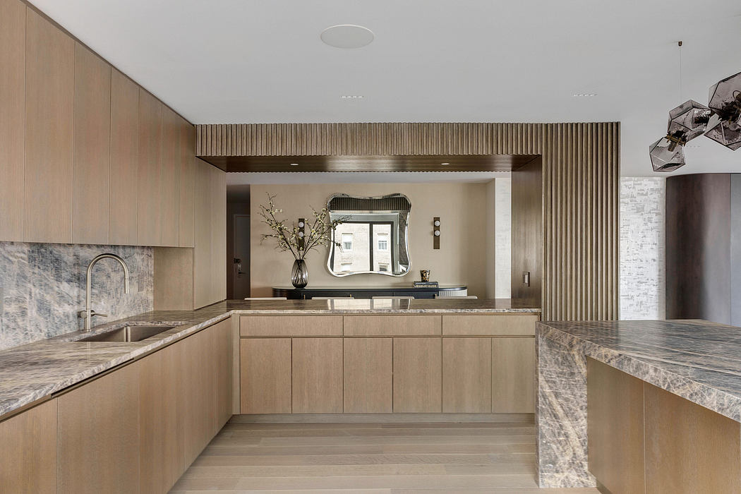 Sleek, modern kitchen with wood cabinetry, marble countertops, and recessed lighting.