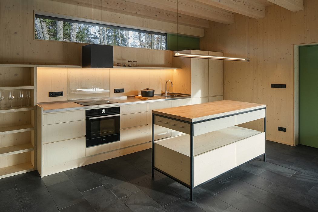 A modern and minimalist kitchen with wooden walls, sleek white cabinets, and a central island.