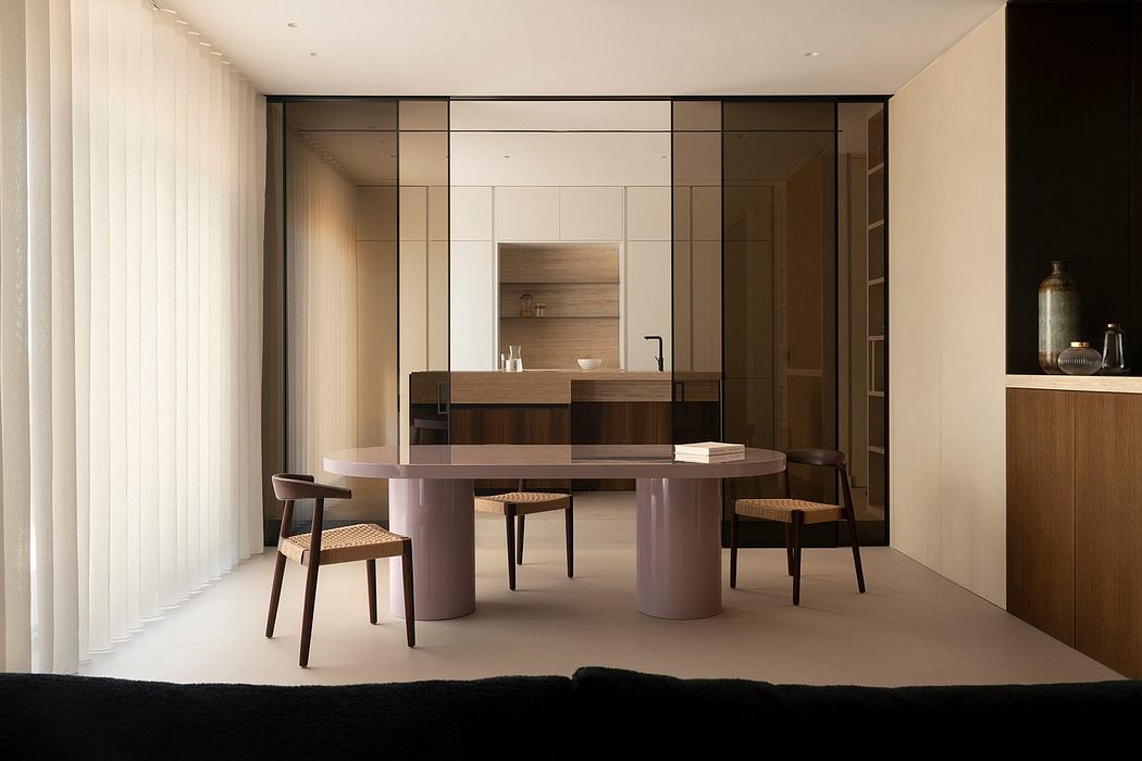 A modern, minimalist dining area with a large circular table, wooden cabinetry, and geometric patterns.