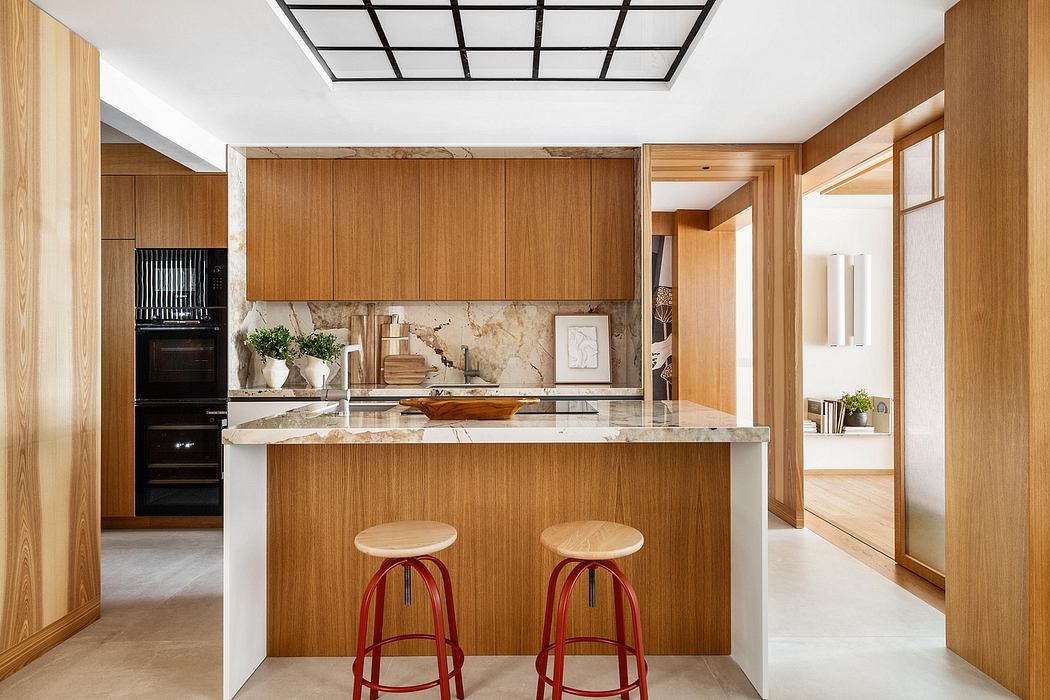 An elegant, modern kitchen featuring a sleek, wooden cabinetry, marble countertops, and pendant lighting.