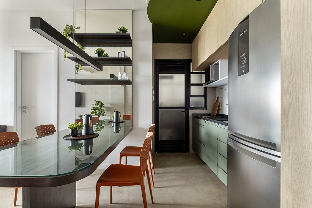Sleek, minimalist kitchen with glass dining table, built-in shelves, and stainless steel appliances.