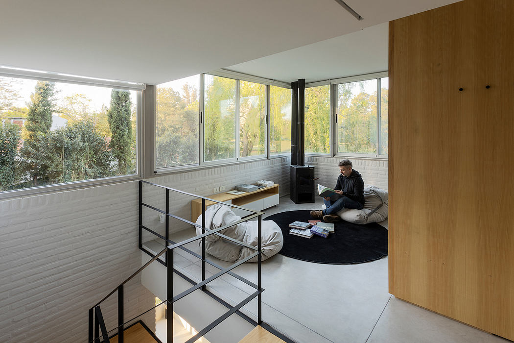 Warm, modern interior with ample natural light, metal shelving, and a cozy reading nook.