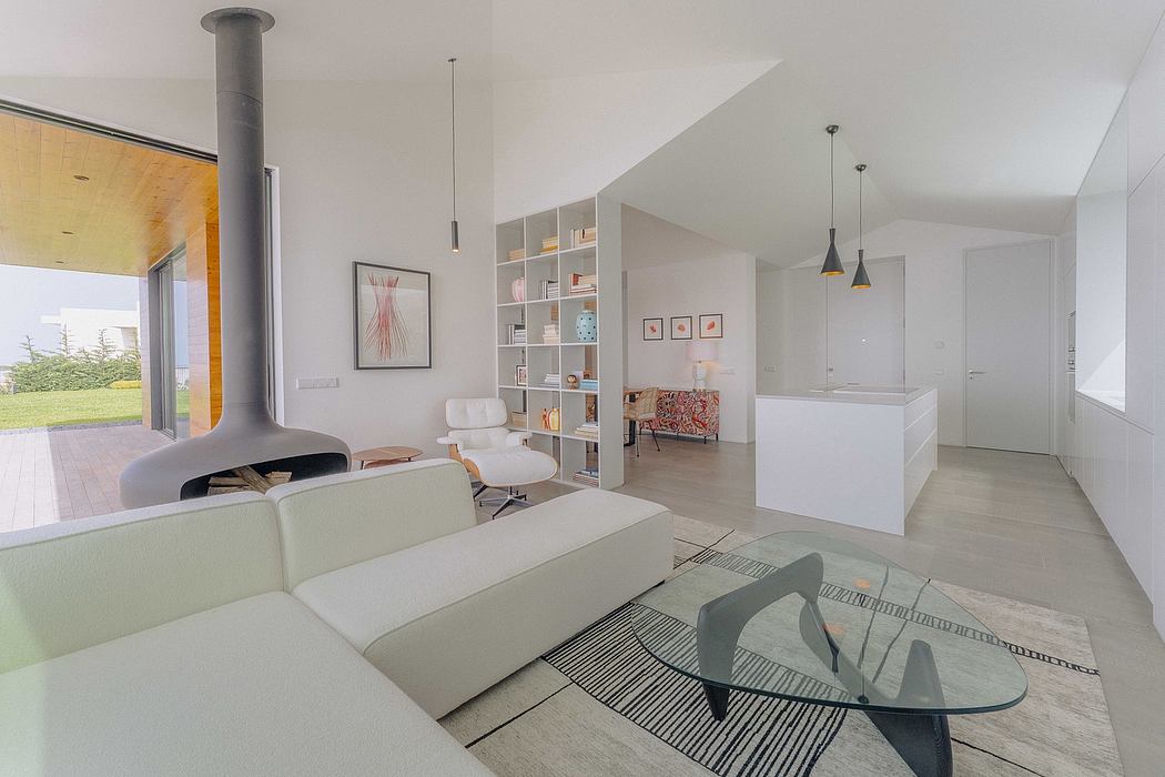 Spacious, minimalist living area with fireplace, glass coffee table, and shelving.