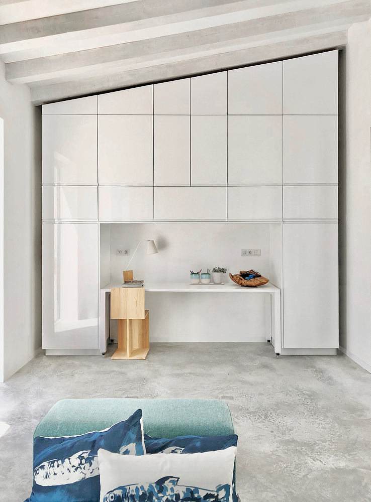 A minimalist workspace with modular storage units, shelves, and decor accents.