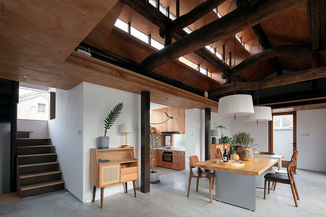 Warm, rustic interior with exposed wooden beams, modern furniture, and central kitchen island.