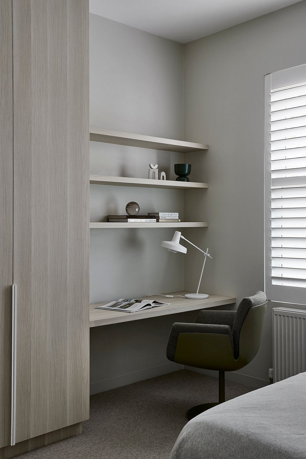 Minimalist bedroom design with built-in shelving, desk, and neutral color palette.
