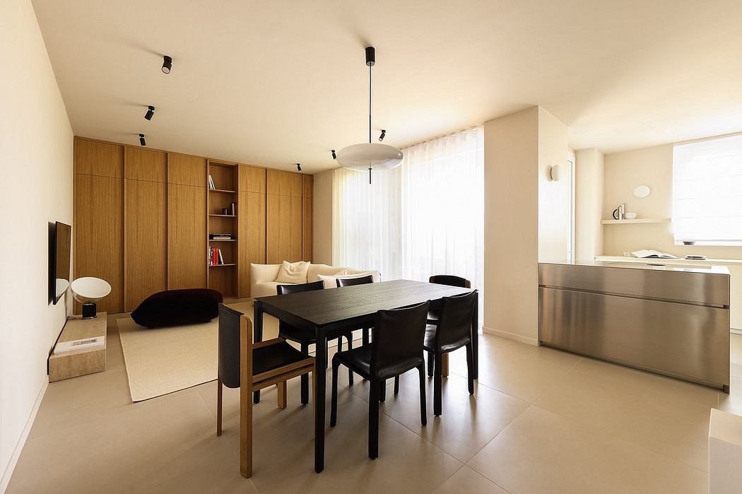 An elegant, minimalist living space with wooden cabinetry, a modern dining table, and sleek appliances.