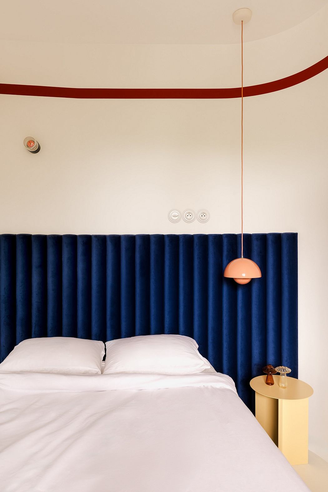 A modern bedroom with navy blue curtains, a pendant light, and minimalist decor.