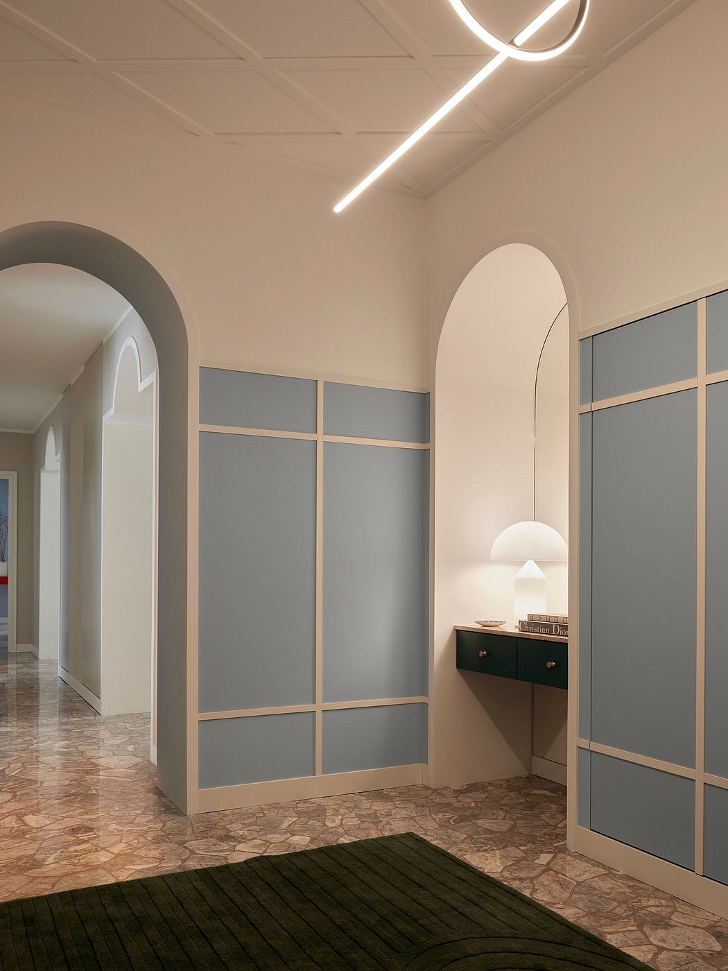 A modern, minimalist hallway with arched entryways, sleek built-in cabinets, and a striking overhead lighting fixture.