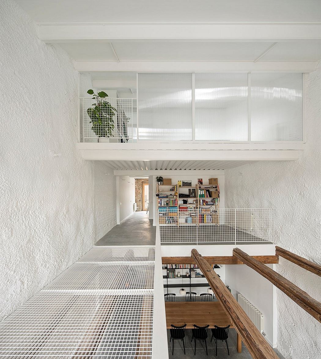 A minimalist loft-style interior with a raised platform, metallic shelves, and wooden accents.