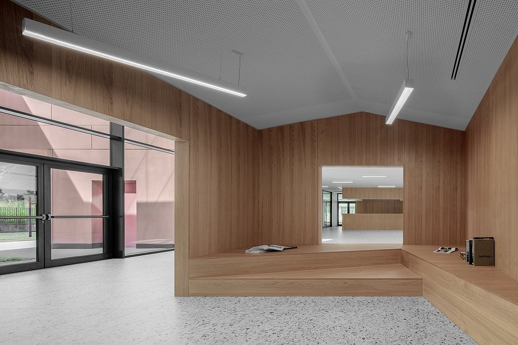 A spacious, well-lit room with sleek wooden walls, modern lighting, and a raised platform.