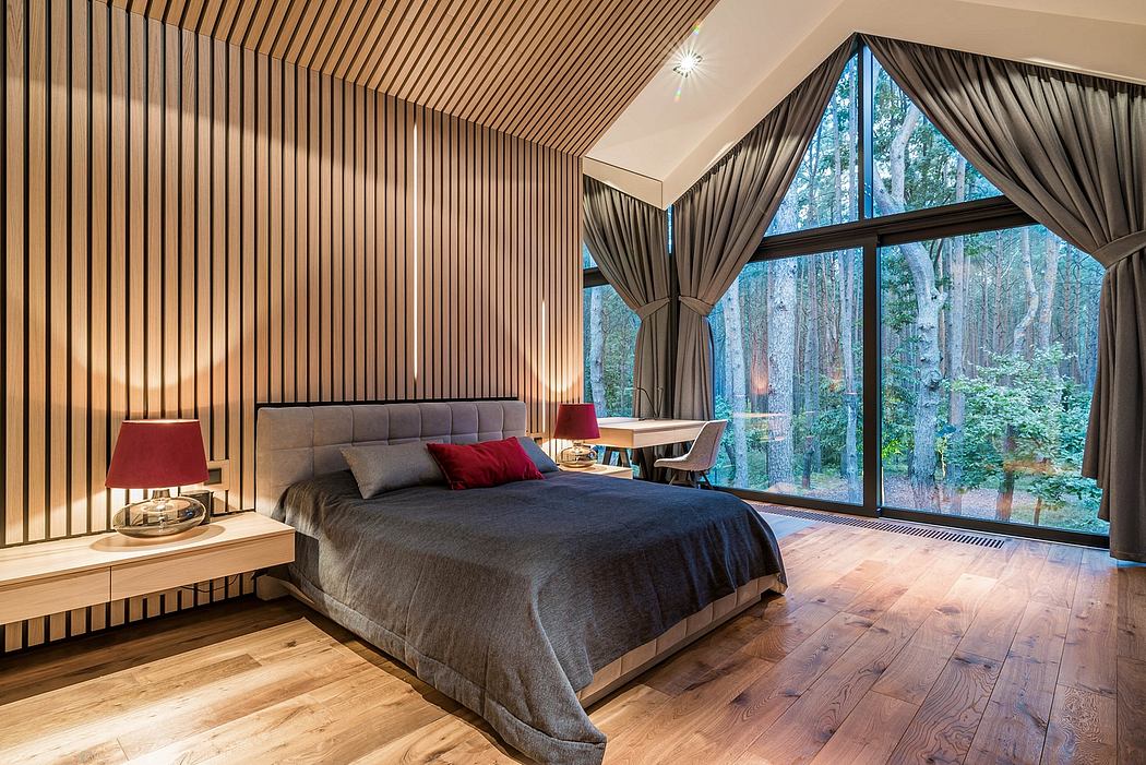 Spacious bedroom with wood-paneled walls, curtains, and panoramic forest views.