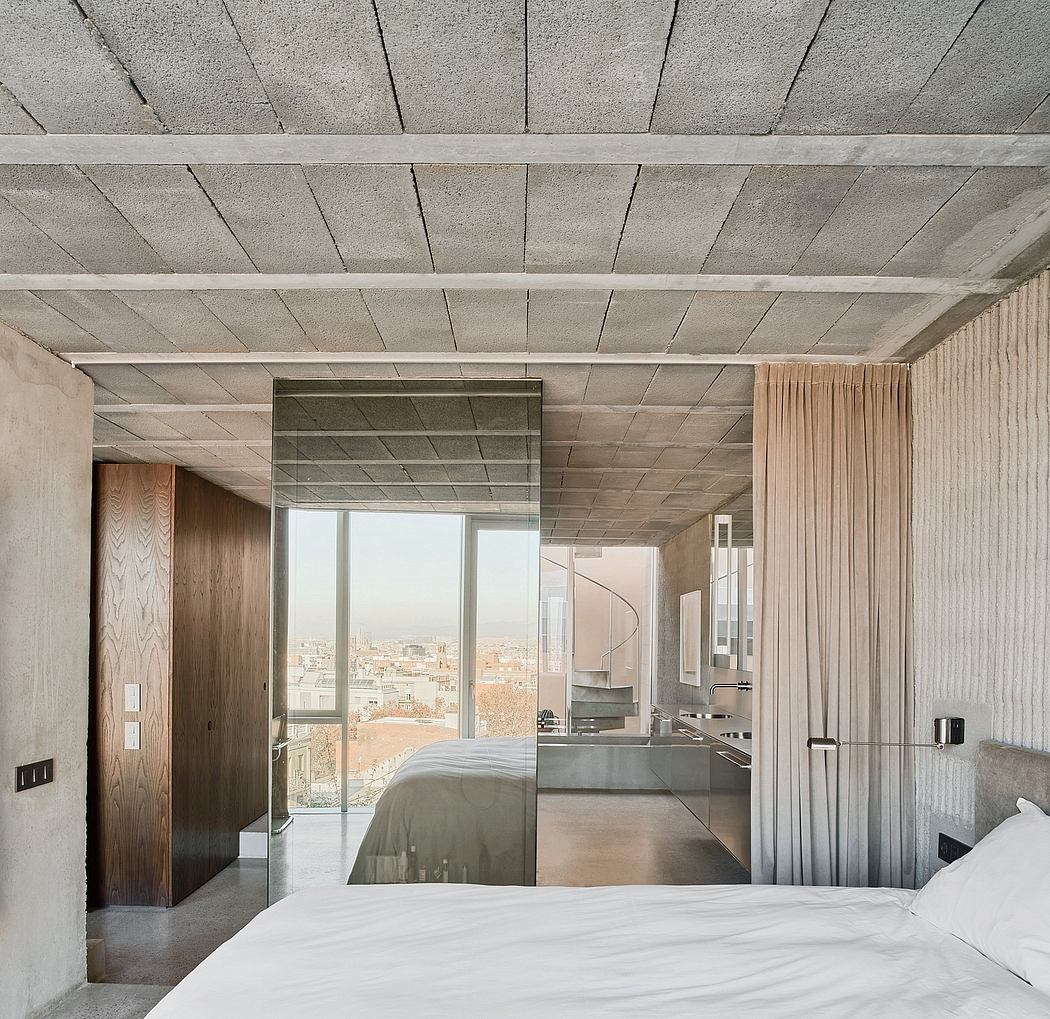 A modern, minimalist bedroom with an open floor plan, large windows, and a concrete ceiling.