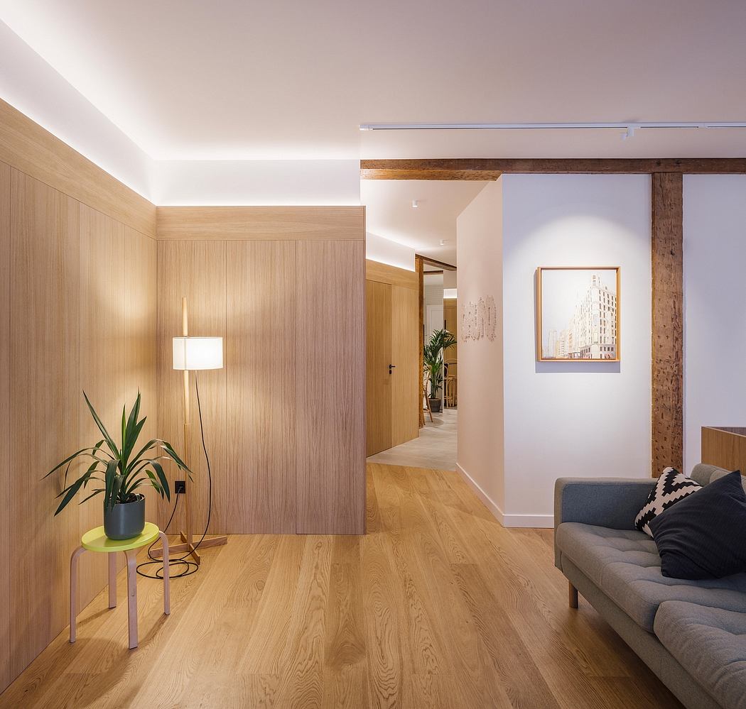 A modern, minimalist living room with warm wood paneling, minimalist furniture, and artwork.