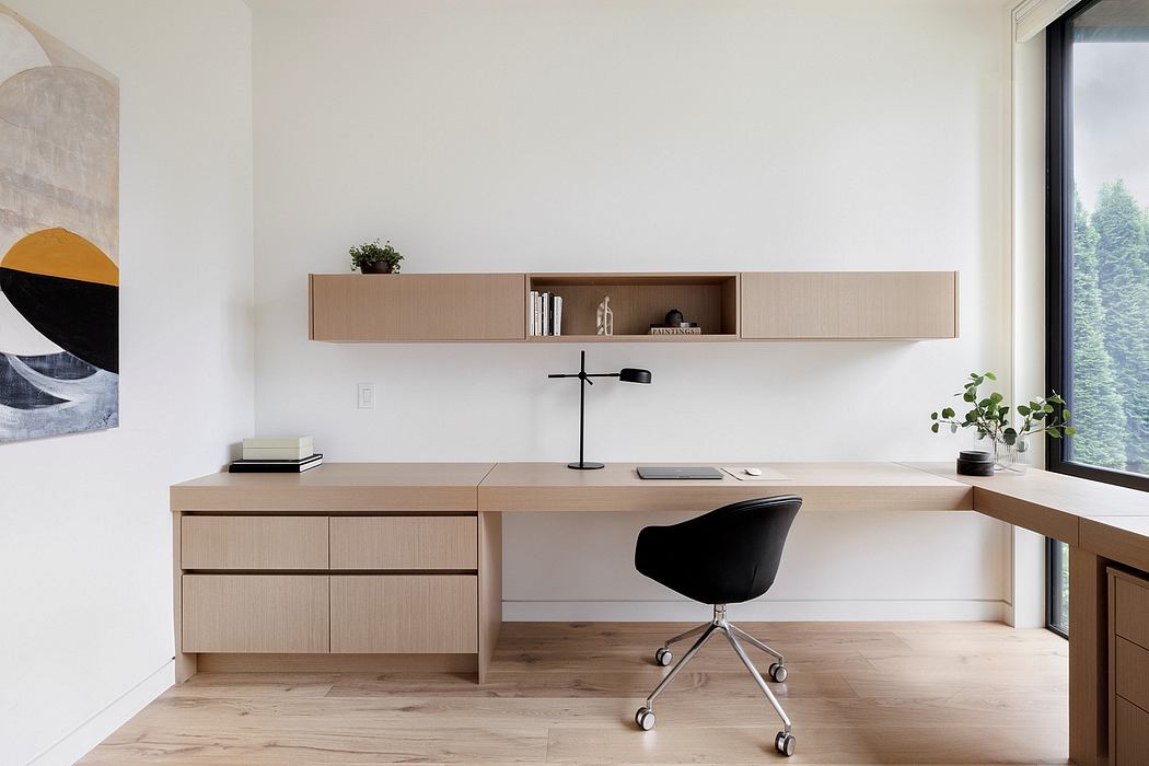 Minimalist home office with sleek wooden cabinetry, desk, and a black swivel chair.