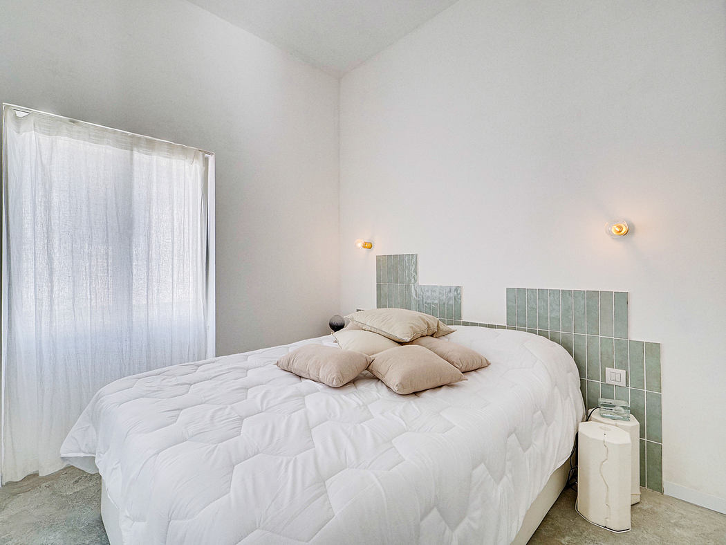 Modern minimalist bedroom design with white walls, a large bed, and tiled accents.