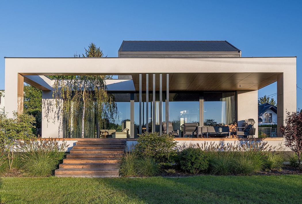 Modern glass and wood patio pavilion with steps leading up to a covered living area.