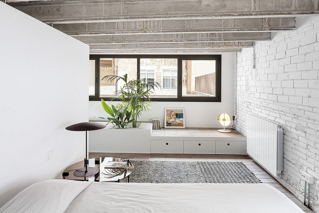 Minimalist loft-style interior with exposed brick walls, large windows, and built-in storage.