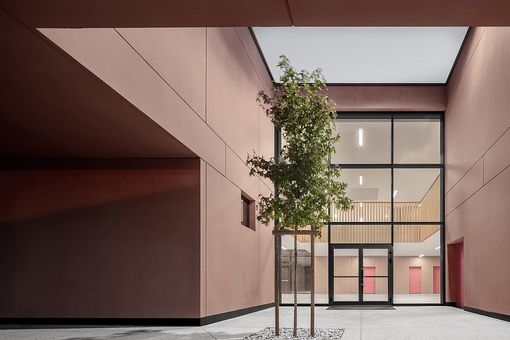 A modern architectural interior with a central tree, glass walls, and warm-toned walls.