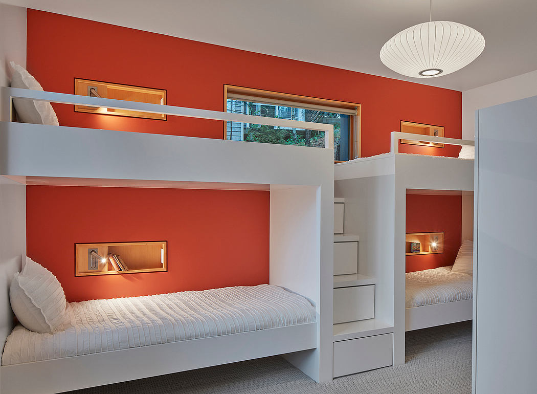A modern bunk bed design with built-in storage and an accent red wall, creating a stylish and functional space.