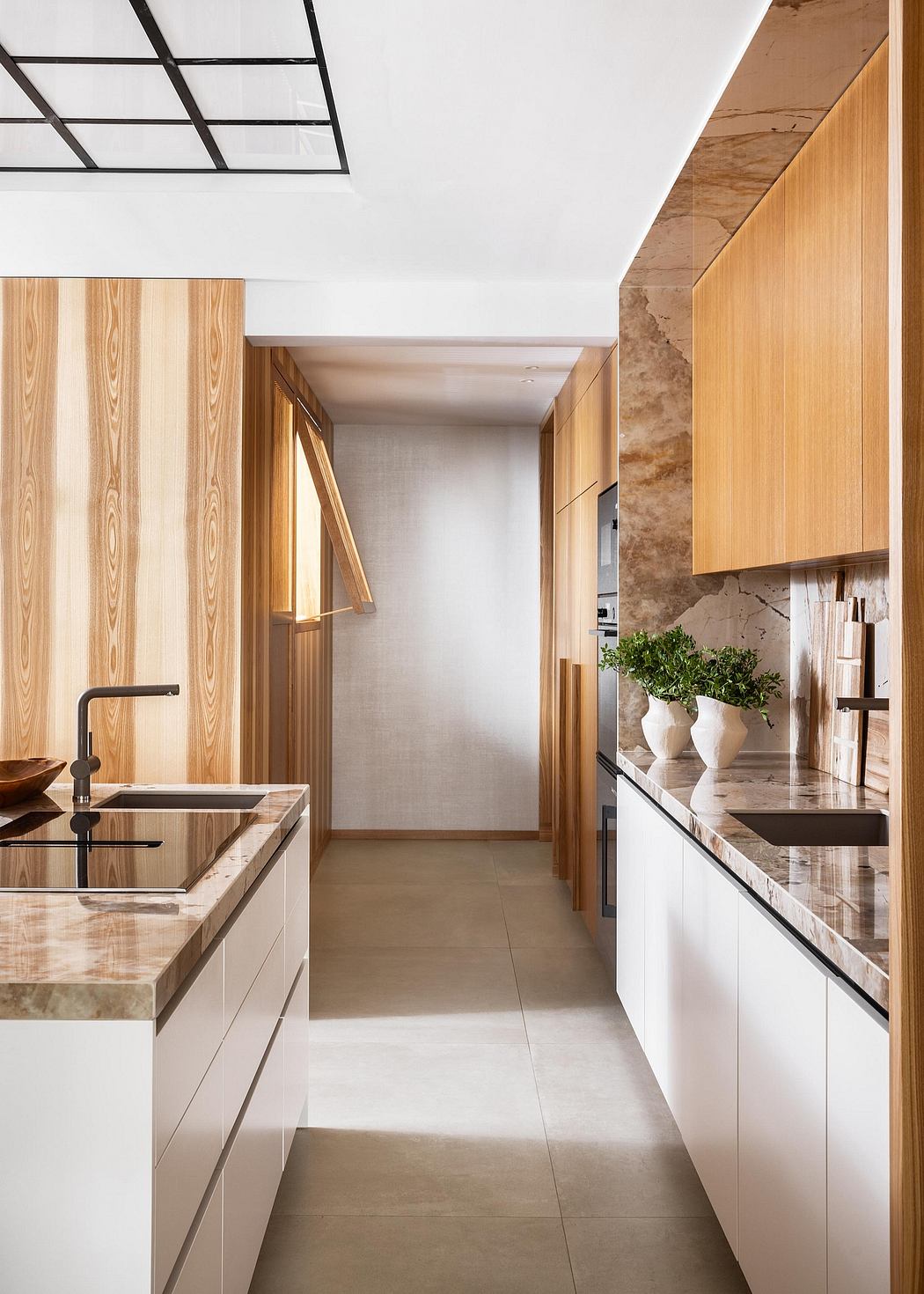 A modern kitchen with a mix of natural wood, stone, and minimalist white cabinetry.