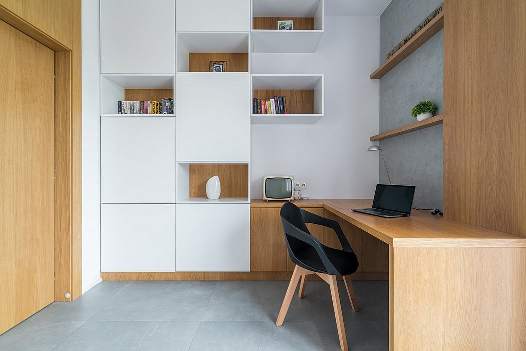 Minimalist home office with custom built-in shelving, wood desk, and concrete floor.