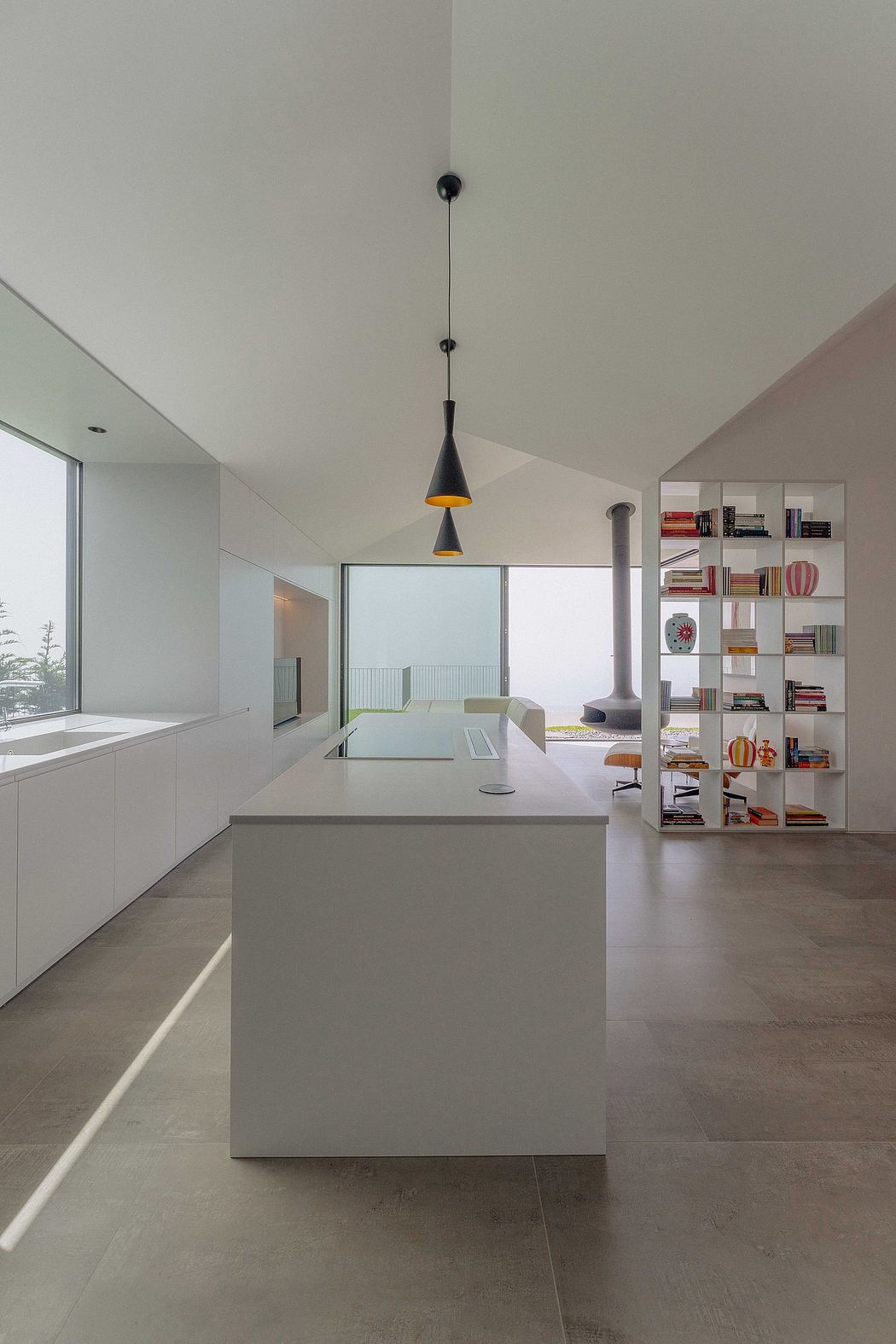 Minimalist interior with modern lighting, built-in shelves, and sleek kitchen island.