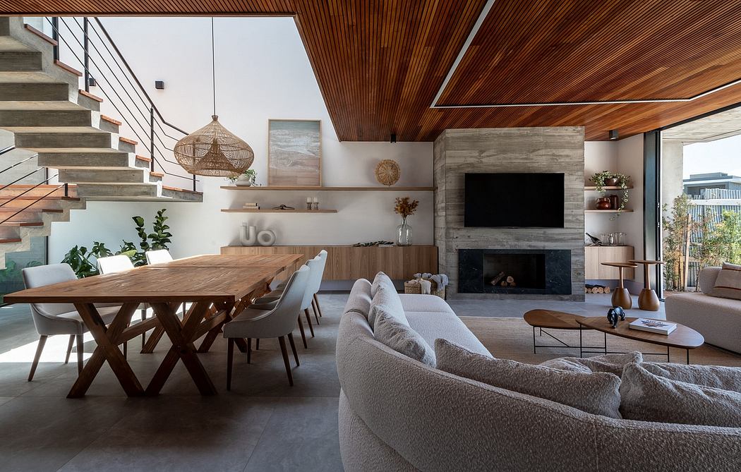 Spacious open-plan living area with modern wooden accents, stone fireplace, and plush furnishings.