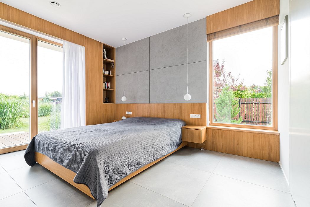 Spacious and modern bedroom with wooden paneling, large windows, and minimalist decor.