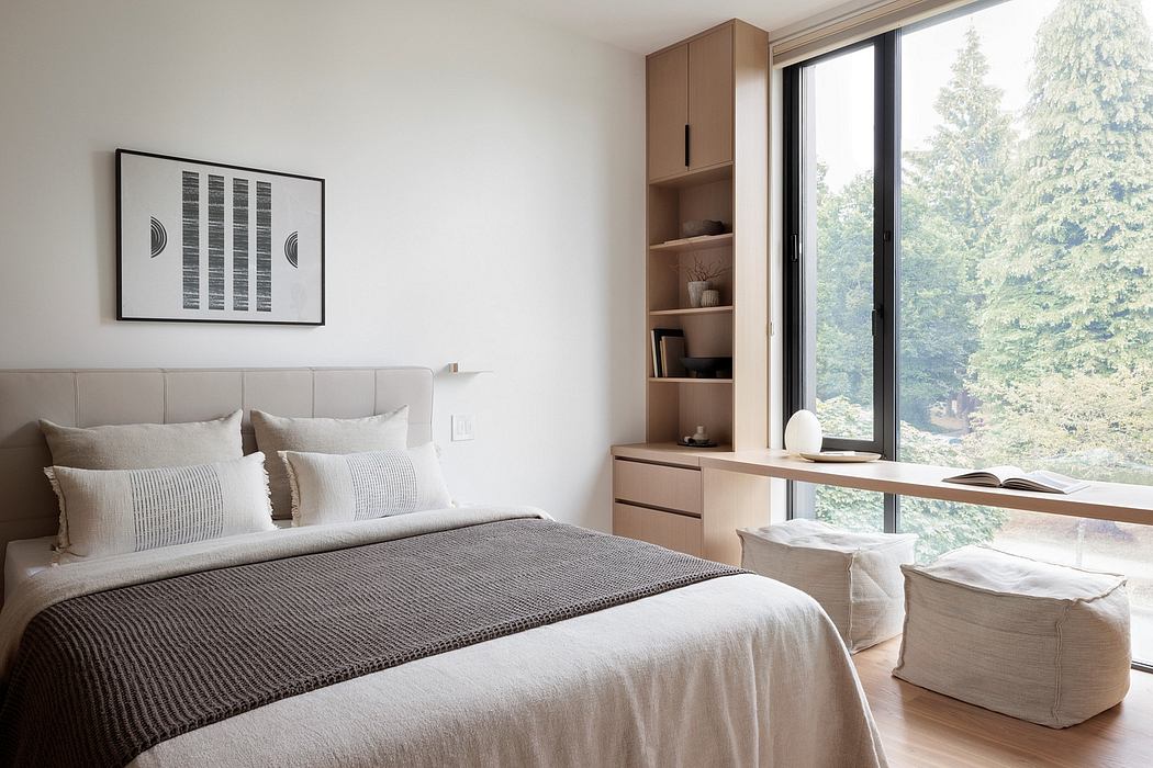 Cozy bedroom with minimalist design, large window overlooking forest, built-in storage.
