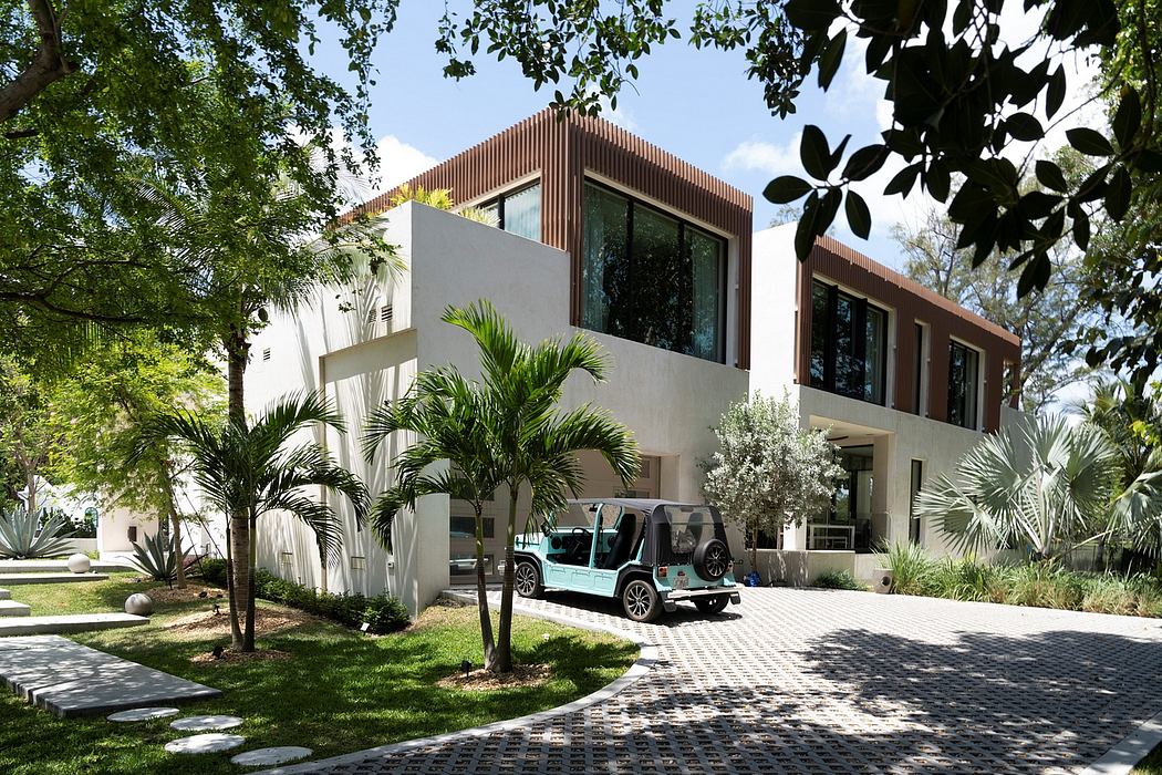 Modern two-story building with unique wooden façade, surrounded by lush tropical landscaping.