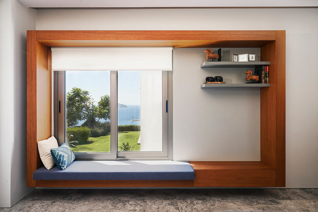 A cozy window nook with built-in shelving, overlooking a lush outdoor landscape.