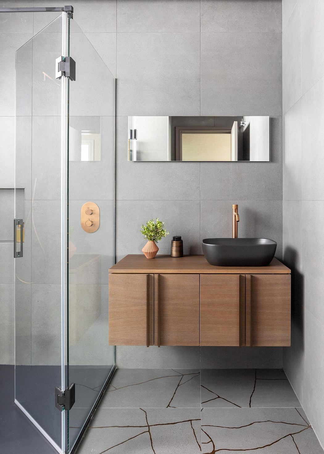 Sleek, modern bathroom with wood vanity, black vessel sink, and glass shower enclosure.