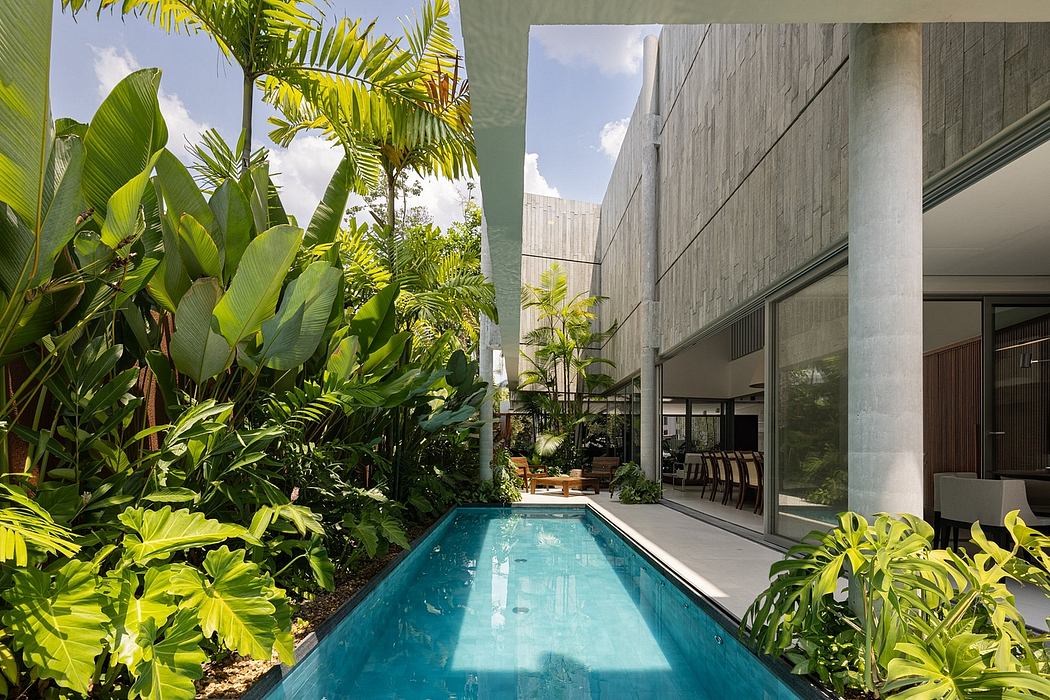 Tropical oasis with an inviting pool, surrounded by lush greenery and modern architecture.