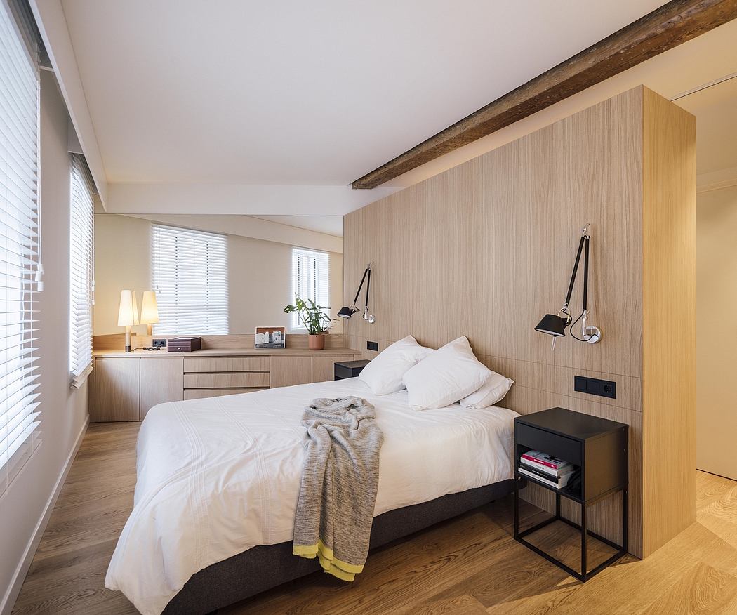 Cozy bedroom featuring wood paneling, lamps, and integrated storage solutions.